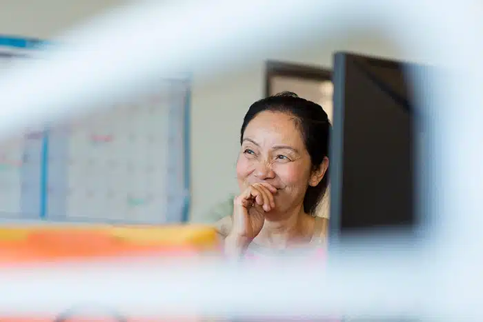 una imagen de una mujer feliz usando su computador