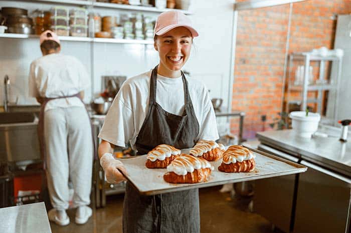 ¿Cómo hacer crecer mi negocio? young woman proudly showing her pastry on camera